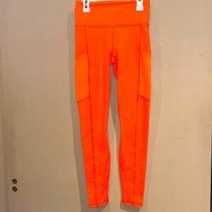 Fabletics Powerhold bright neon orange leggings size XS with mesh side pockets